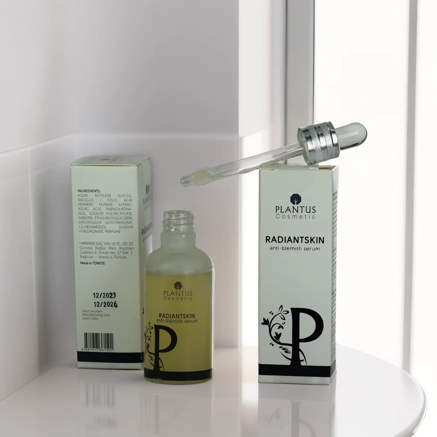 Plantus Radiant Skin Anti-Blemish Serum bottle and box displayed on a surface, featuring their label and droplet applicator.