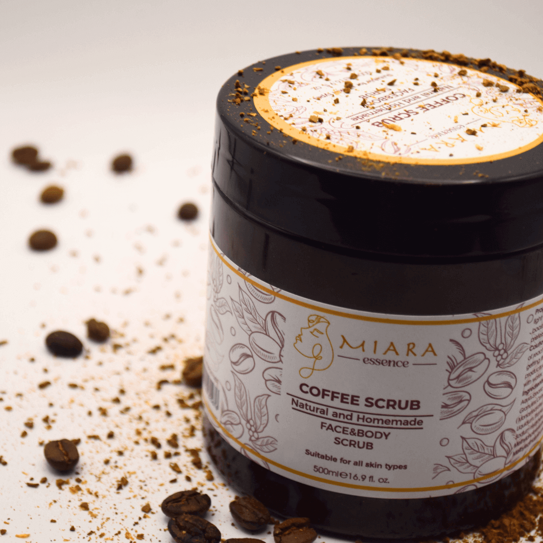 Natural Coffee Scrub by Miara Essence in a jar with coffee grounds and beans around it.