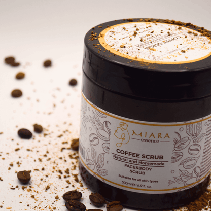 Natural Coffee Scrub by Miara Essence in a jar with coffee grounds and beans around it.