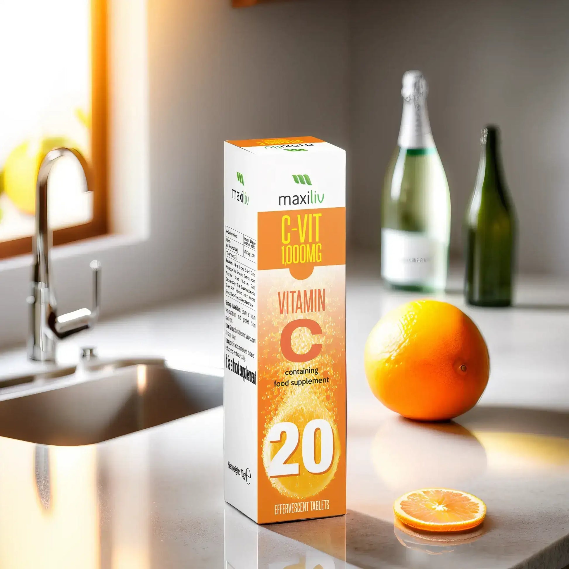 Maxiliv Vitamin C Effervescent tablets box on a kitchen counter with an orange and bottles in the background.