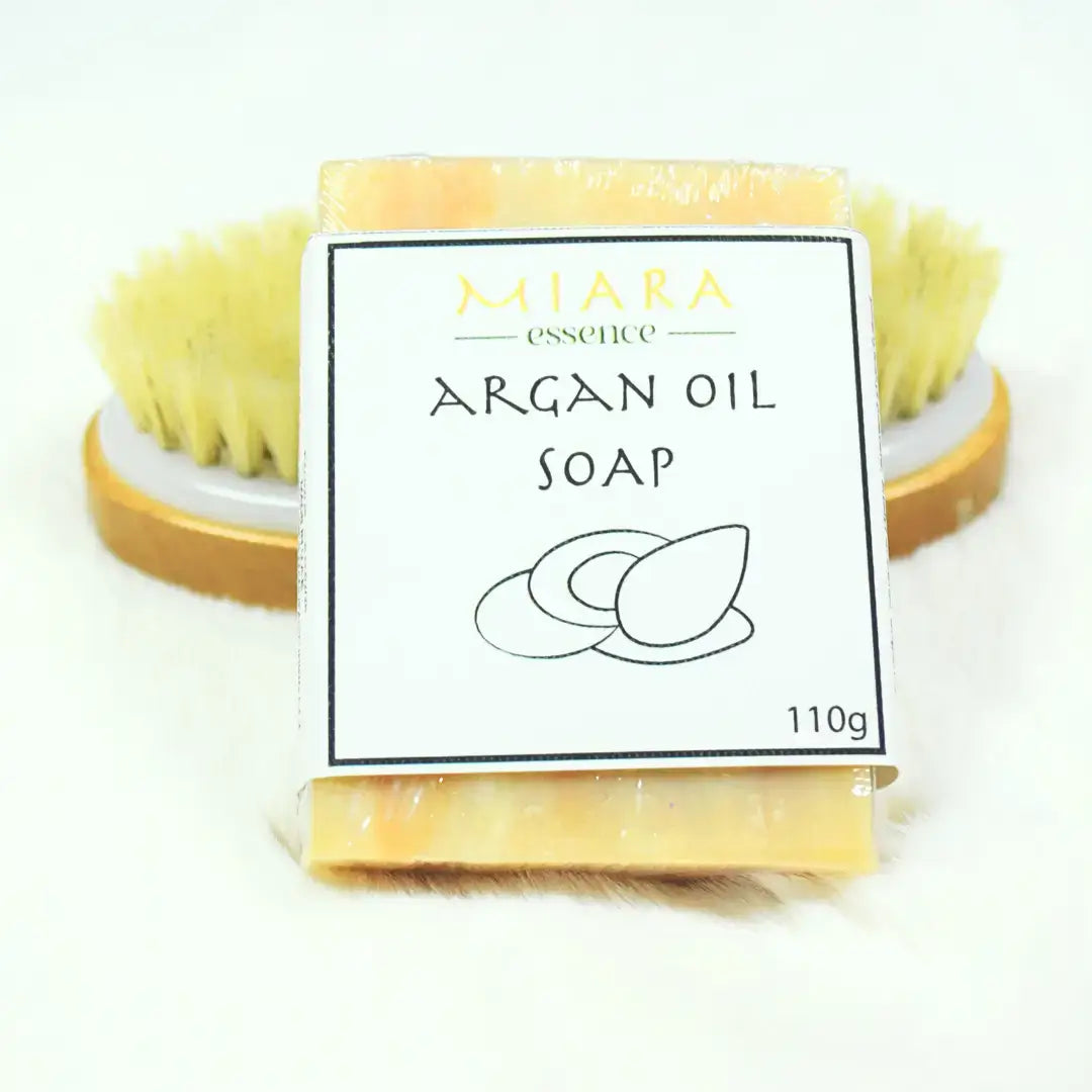 Miara Essence Argan Oil Natural Soap bar with a natural bristle brush, promoting glowing skin and hydration.