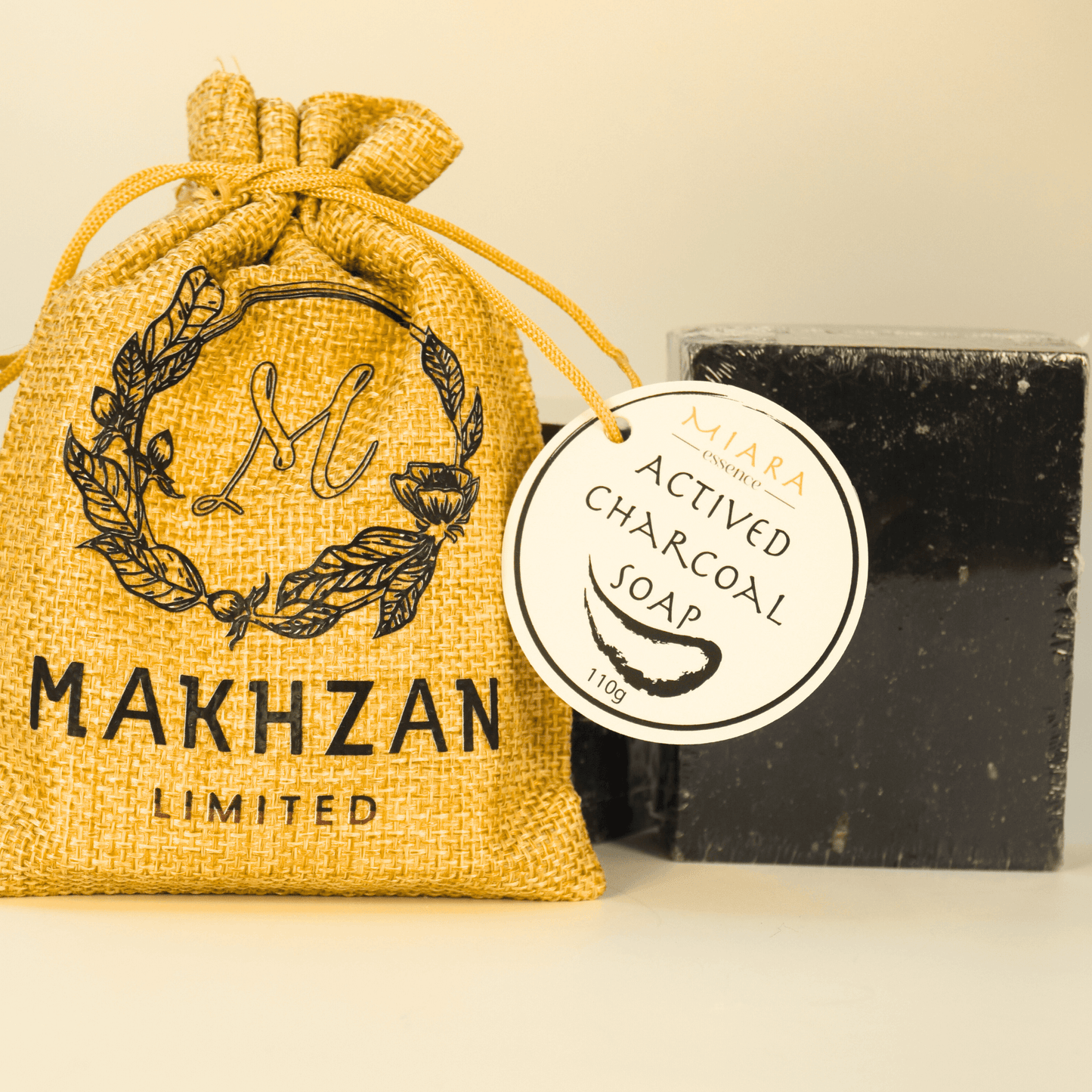 Miara Essence Activated Charcoal Soap packaged in a burlap sack, promoting skin detox and cleansing benefits.